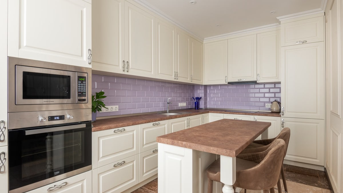 Stylish white kitchen featuring marble countertops and a microwave. Perfect for modern interiors.